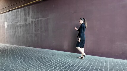 Canvas Print - Woman walking in the city wearing elegant black dress