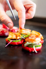 Wall Mural - A close-up of a hand garnishing a vibrant grilled shrimp dish with fresh herbs. The shrimp are perfectly cooked, showcasing a delicious and appetizing presentation.