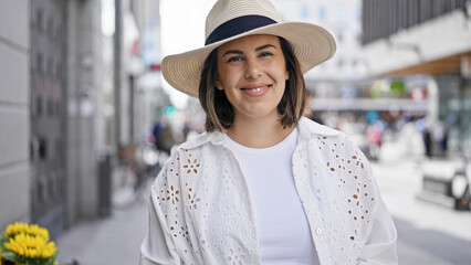 Canvas Print - Beautiful young hispanic woman smiling confident wearing summer hat in the streets of Stockholm