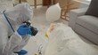 © Krakenimages.com - A man in a hazmat suit photographs evidence at a detailed indoor crime scene investigation.