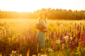 Wall Mural - Young woman twirling in a lavender field at sunset.  Purple lavender field. Collection of medicinal herbs.