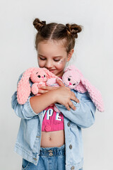 cute little kid girl holding handmade knitted soft toy on white