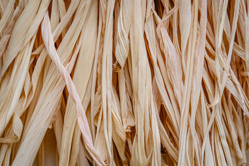 Abstract natural texture and delicate shapes for backdrop surface. Detail of dried corn leaves in golden tones, soft focus. Organic, nature lines and layers