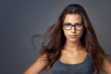 Poster - Wind, hair care and portrait of confident woman with beauty, keratin and texture. Hairstyle, face and model in glasses at hairdresser for salon treatment cosmetics isolated on gray studio background