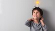 © pkproject - Excited Young Boy with Light Bulb Symbolizing Creativity and Innovative Thinking in Classroom