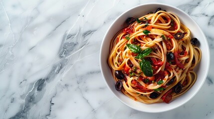 a bowl of pasta puttanesca, on a marble background