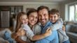 © Denis Yevtekhov - Warm family moments in the living room, parents with two kids, smiling and hugging, modern and inviting home, with copy space