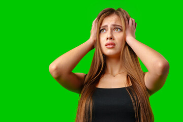 Wall Mural - Young Woman With Long Brown Hair Holds Head in Hands Against Green Screen Background