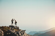 © peopleimages.com - Hiking, high five and couple on mountain with sky for adventure, cliff trekking and fitness. Travel, nature and people for mockup space and exercise achievement on holiday, journey or vacation
