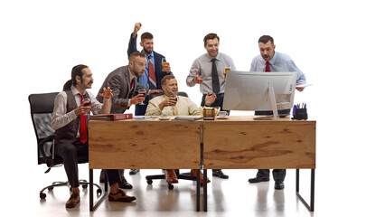 Cheerful young male workers drinking alcohol drinks, beer and watching sport event on PC against white studio background. Concept of sport events, betting, recreation, match, game, support.