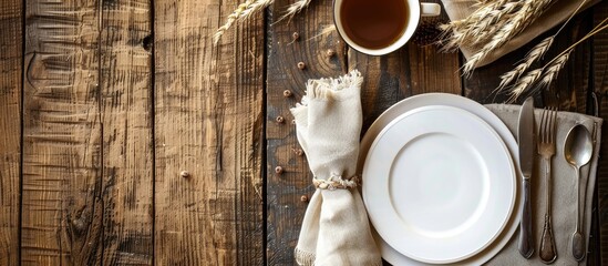 Poster - View from above showing a dining table set with a mock up plate silverware cup napkin and golden wheat decoration featuring copy space image
