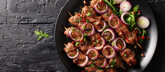 Poster - A raw marinated kebab with onions and spices displayed on a black plate in a top view with available copy space image