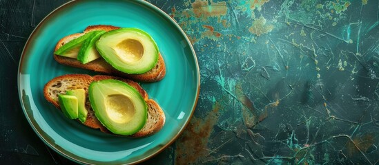Poster - Top view of two avocado toast slices on a dark background displayed on a turquoise plate providing copy space image