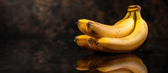 Poster - Juicy ripe bananas set against a reflective black background with selective focus for a copy space image