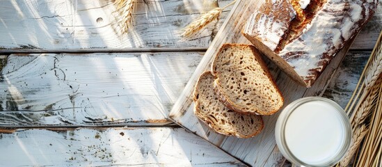 Poster - Copy space image of sunlight illuminating rye bread on white wood beside a glass of milk