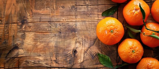 Poster - Top view of ripe mandarins on a wooden surface with a clear area for additional content ideal for a copy space image