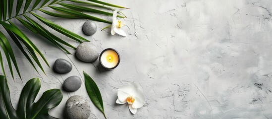 Aufkleber - Zen like grey stones a candle flower and palm leaves arranged on white stone background for a relaxing spa concept viewed from above with empty space for text or image. Creative banner