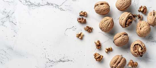 Poster - Top down view of walnuts in shells on a white stone surface ideal for adding text to the image. Creative banner. Copyspace image