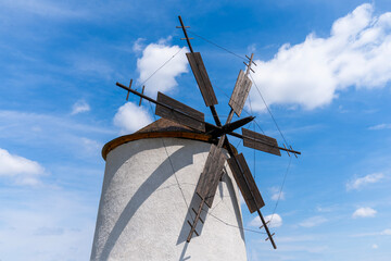 Old traditional windmill with cloudy blue sky in the background