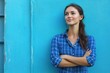 © tomatobear - A woman in a blue plaid shirt is standing in front of a blue wall