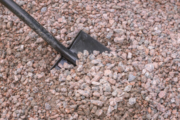 Shovel stuck in a pile of gravel.