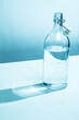 © Bidwell Studio - Clear glass water bottle with glass, cyan tinted