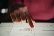 © DragonImages - Close-up shot of hand interacting with touchscreen device during business presentation in dark setting, showing detailed information on screen