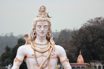 Wall Mural - Portrait of Shiva meditating on the banks of the Ganges. Statue in Rishikesh.