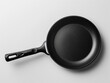 © pavlofox - A close-up view of a sleek black frying pan on a gray surface
