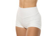 © vladimirfloyd - cropped view of a young sporty woman posing in tight white sexy shorts on a white background in the studio. Front view.