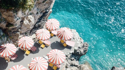 Wall Mural - Aerial View of Coastal Beach with Red and White Striped Umbrellas by Turquoise Sea