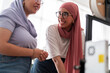 © Studio Marmellata - Two women in hijabs smile as they collaborate on a 3D printing project, demonstrating teamwork and a positive working environment. They are engaged in a discussion about the project.