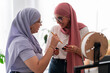 © Studio Marmellata - Two women in hijabs engage in a discussion about 3D printing components. They hold parts and tools, showcasing their involvement in the technical aspects of the project.