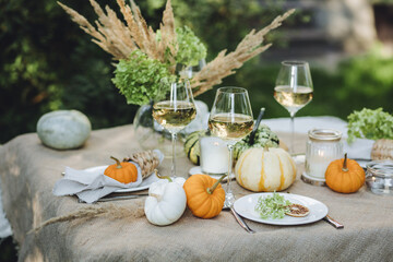 Wall Mural - Simple craft elements, pumpkins as decoration, candles. Lunch outdoors in the garden. Cozy dinner table decor for an autumn event, countryside party, thanksgiving dinner or wedding. 