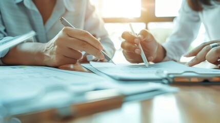 Two people actively collaborate on business documents while enjoying morning sunlight in a modern office