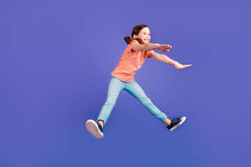 Poster - Full size photo of pretty little girl jumping pushing invisible things wear trendy red outfit isolated on purple color background