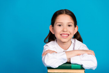 Poster - Portrait of little schoolkid folded arms book empty space wear uniform isolated on blue color background