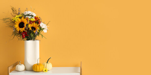 Wall Mural - Shelving unit with bouquet of autumn flowers and pumpkins near orange wall