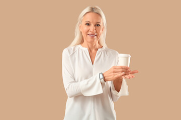 Sticker - Mature woman with cup of coffee on brown background