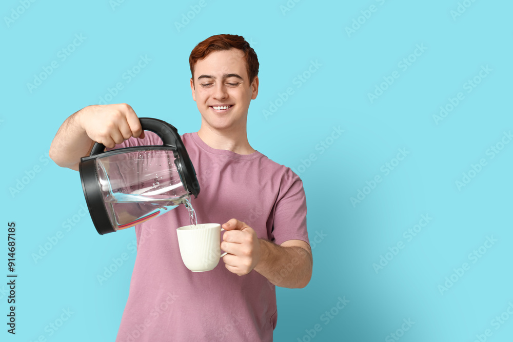 Handsome young man pouring hot water from modern electric kettle into cup on blue background