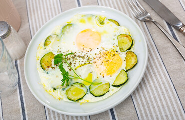 Wall Mural - Delicious fried eggs with pieces of zucchini and herbs served on platter