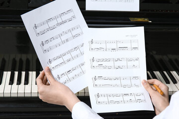 Poster - Young woman holding note sheets near piano