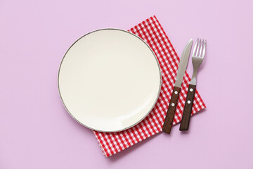 Sticker - Table setting with plate, cutlery and checkered napkin on purple background