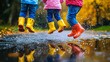 © Kingboy - Children in colorful rain boots jumping in a puddle on a rainy day