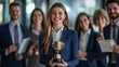 © Oulaphone - Business success concept. Happy winner businesswoman receives a business award and holding trophy with team of cheerful workers. Celebrating and congratulating their leader on great work success.
