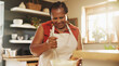 © AzeemudDeen/peopleimages.com - Baking, smile and black woman with bowl in kitchen for cake, muffins or dessert at home. Happy, mix and mature African female person with utensil for preparing dough or bread recipe at house.