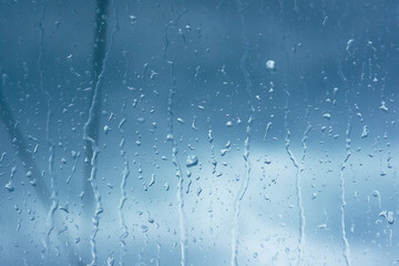 Wall Mural - Rain drops close up on window glass outdoors. Texture of water in heavy rain. Gloomy autumn morning. Macro	