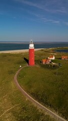 Wall Mural - Experience the iconic lighthouse of Texel, brilliantly set against a breathtaking beach landscape in the beautiful Netherlands. This location is a picturesque coastal gem worth visiting