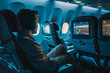 © Nomad_Soul - Passenger watching a movie on the in-flight screen in a modern plane cabin. Generative AI