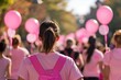 © anzodesign - Community event with participants in pink shirts walking together and carrying balloons in the park on a sunny day